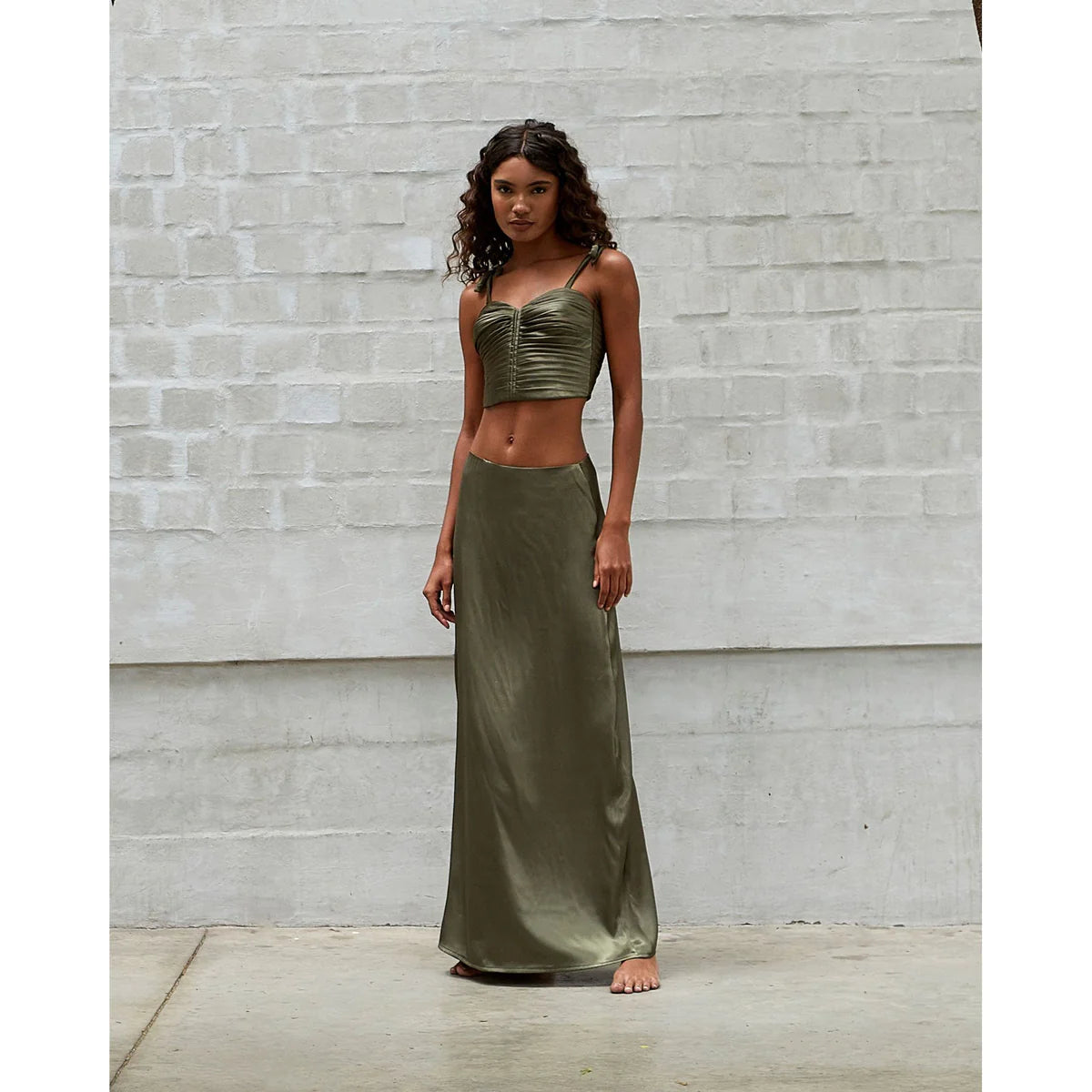 a afroamerican model showing us how to style long skirts like the green olive that she is wearing with a green olive top in a OnPost style