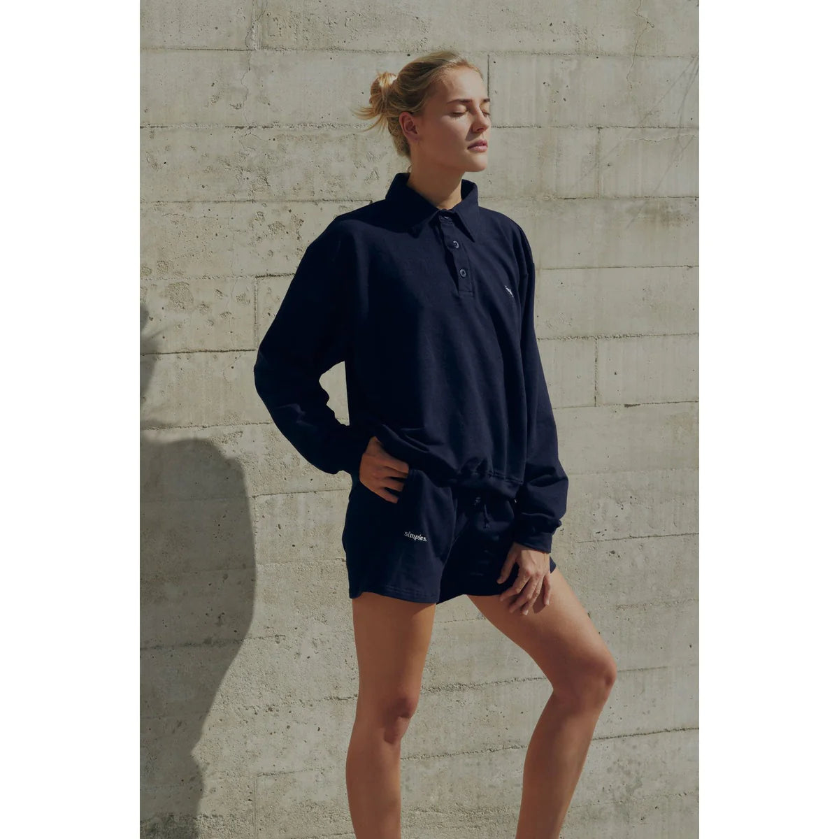 a blonde model showing how to style navy blue with shorts and a shirt in this color
