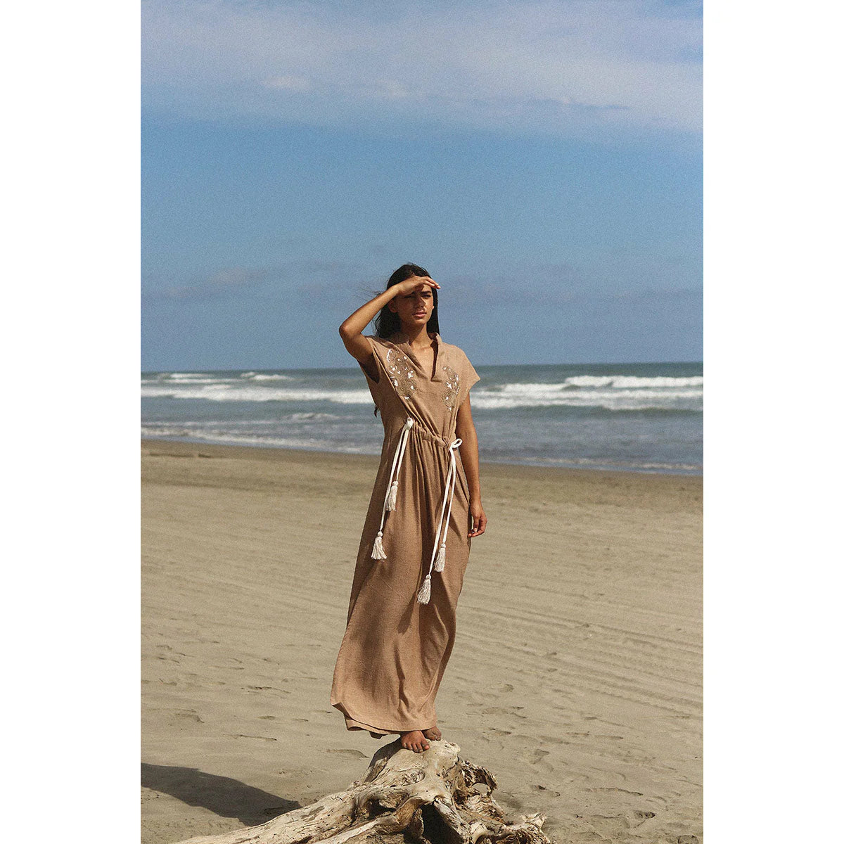a brunette model in the beach showing how to style a brown dress